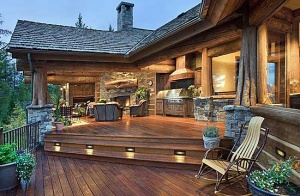 Exterior, horizontal, rear deck overall toward fireplace and built in bar-b-que at twilight, Witt residence, Whitefish, Montana; High Country Builders; The Old World Cabinet Company